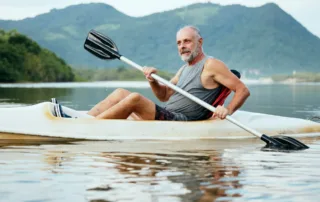 photo - a man kayaking in a lake, wondering how to get TRT in Canada