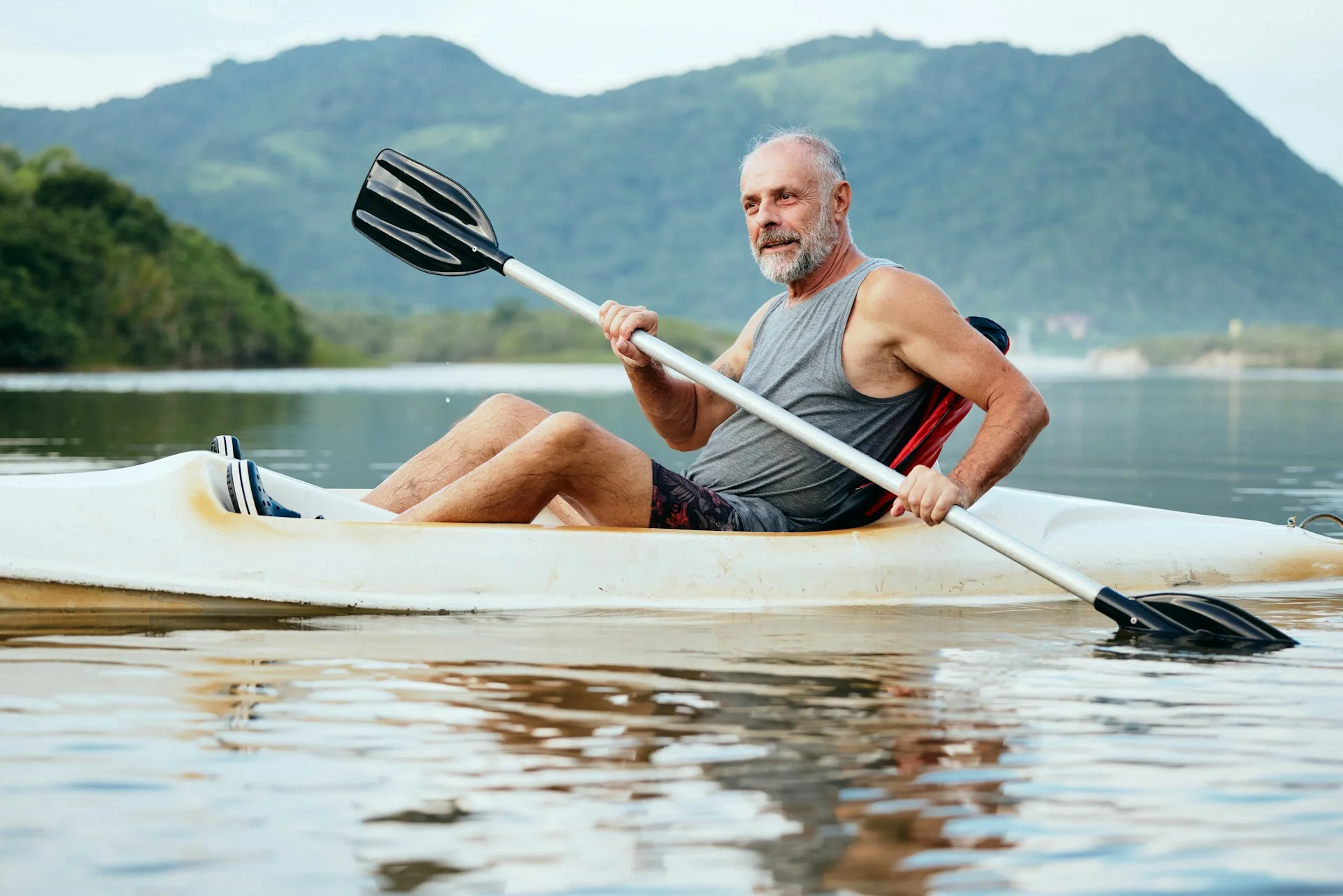 photo - a man kayaking in a lake, wondering how to get TRT in Canada