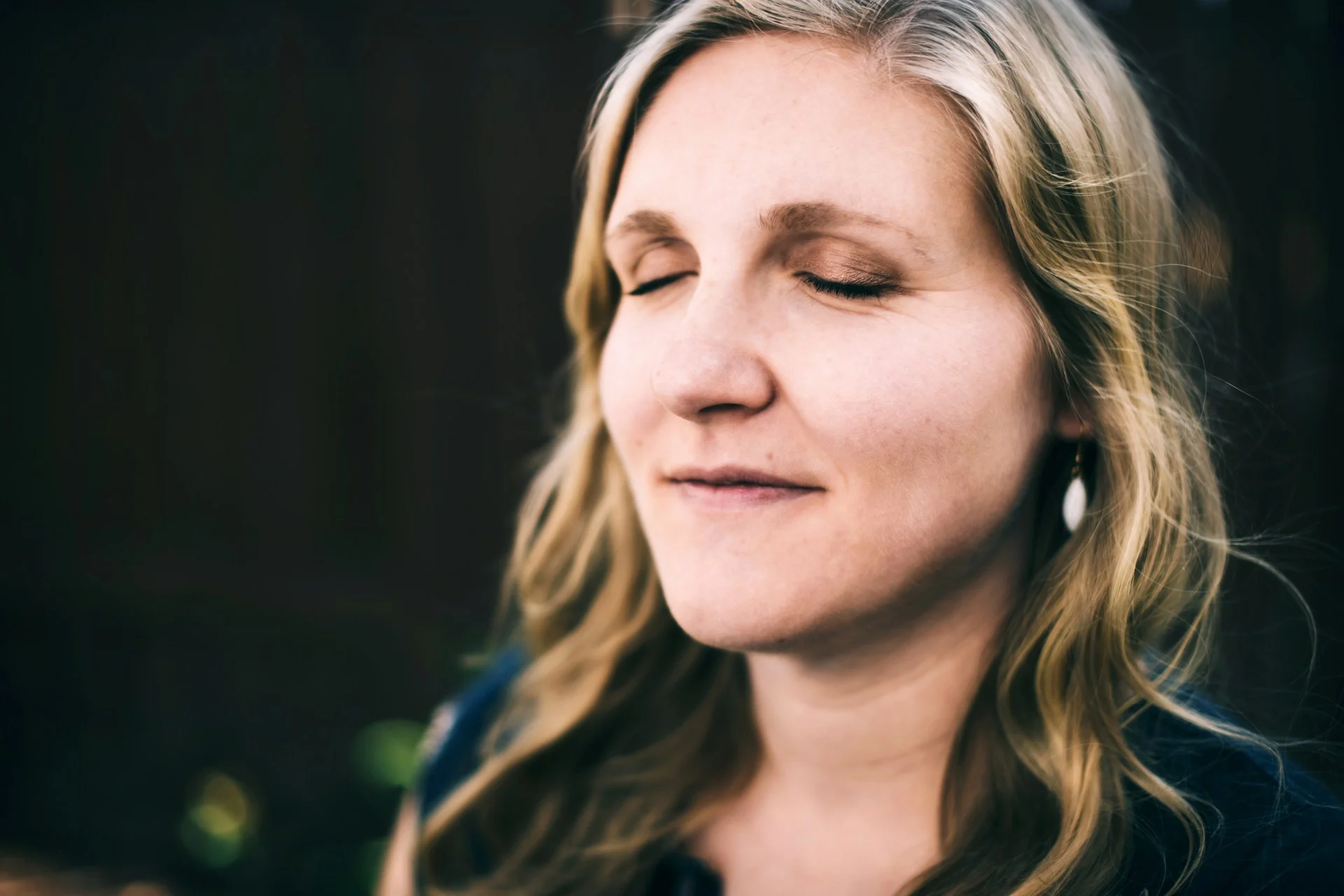 photo - a happy woman with closed eyes in the park after reading the best menopause books