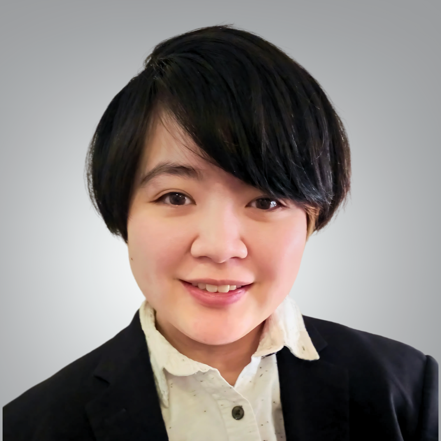 Professional headshot of Kade Chung, a new administrative assistant at Red Leaf Wellness, smiling warmly in a white shirt and dark blazer.