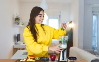 photo - a woman making a smoothie for adrenal glands and pcos