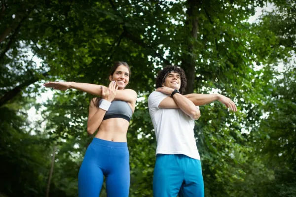 photo - a couple stretching under trees as a part of natural ways to cure heartburn