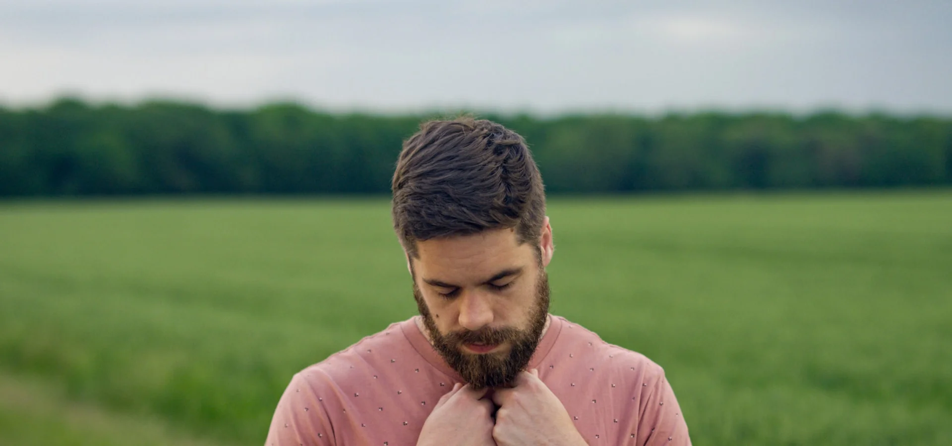 photo - a struggling man looking down in a field going through male hormone cycle