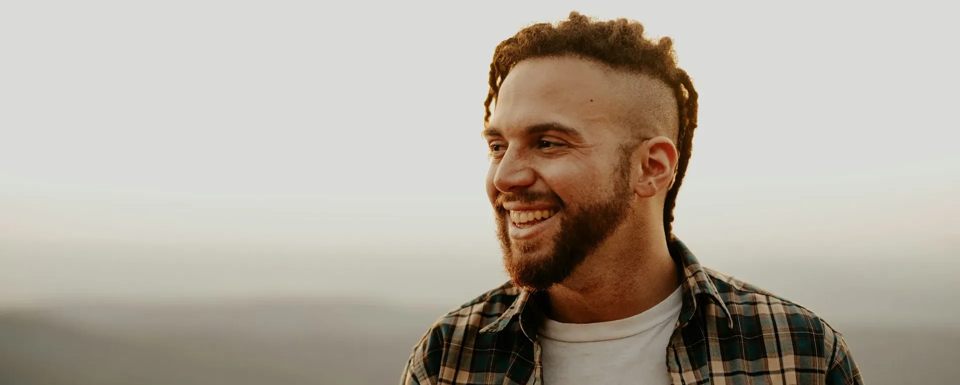 a happy man smiling out in nature thinking about before and after testosterone supplement