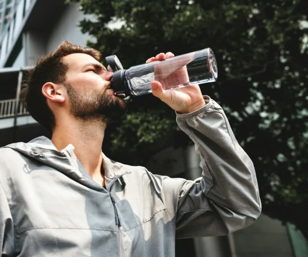 a man drinking water after taking liquid probiotics