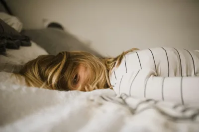 photo - a woman laying in beg with uti bloating