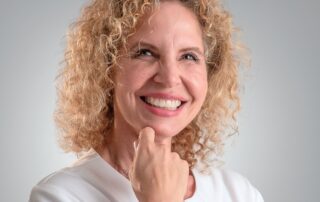 Smiling Nurse Practitioner Stacy Recalla in a white medical coat, representing compassionate hormone health care.
