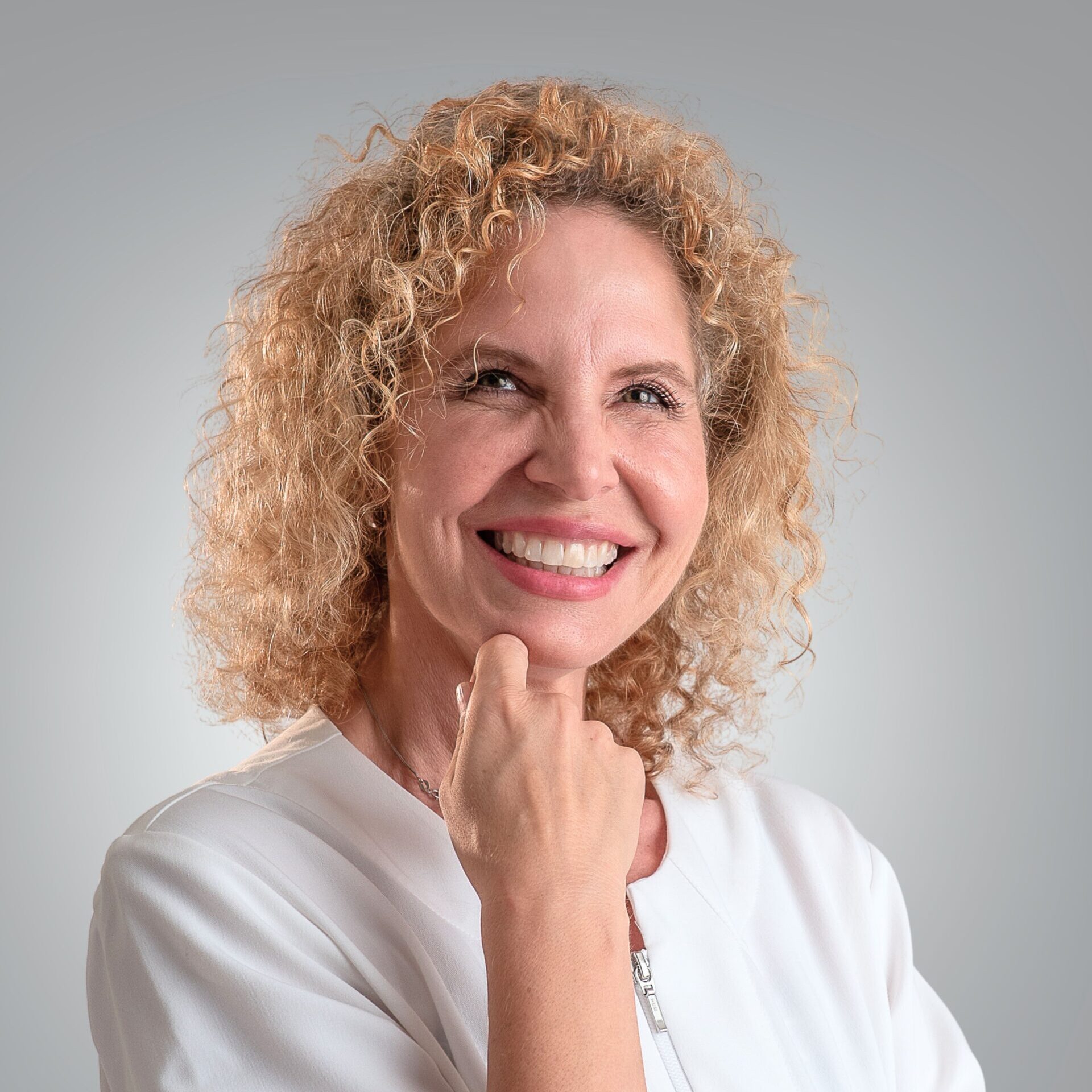 Smiling Nurse Practitioner Stacy Recalla in a white medical coat, representing compassionate hormone health care.