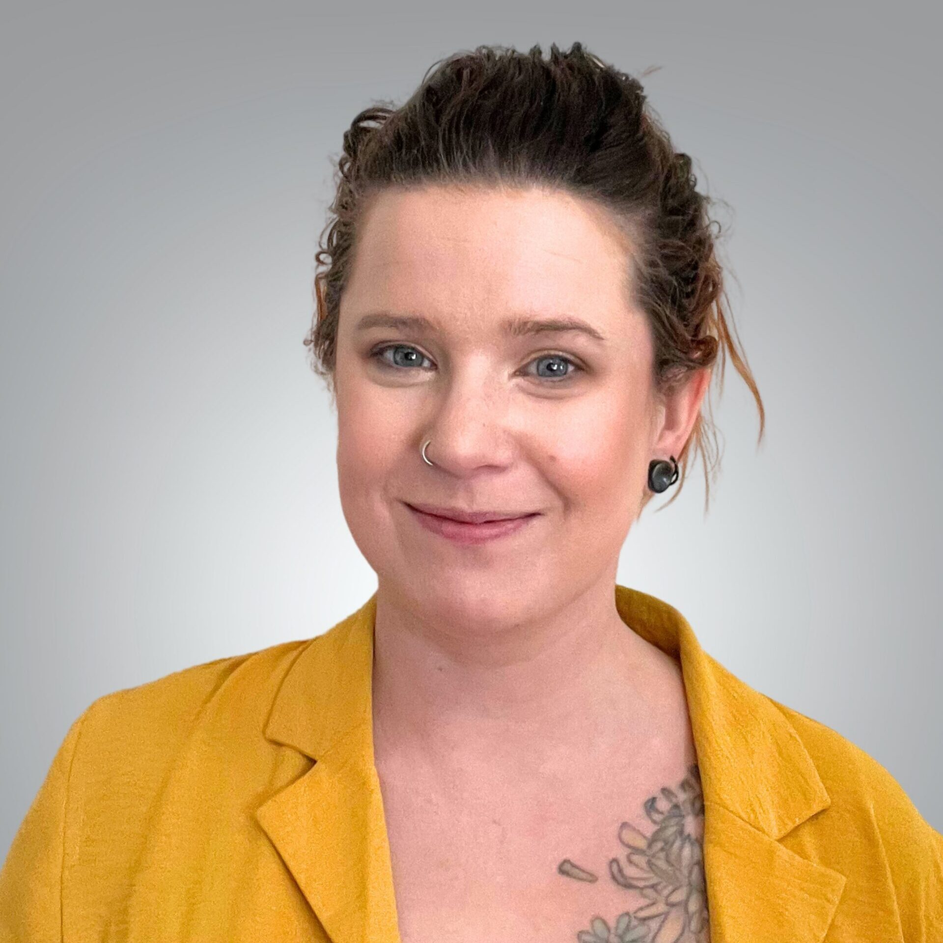 Portrait of Lia Crotenko, patient care coordinator, wearing a mustard jacket and smiling at the camera