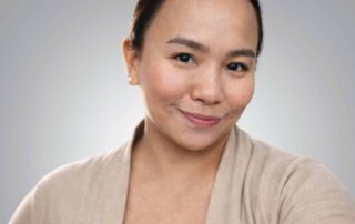 Lee-Anne Cunanan RMT MOT professional headshot with soft grey background and natural studio lig - Red Leaf Wellness Edmonton