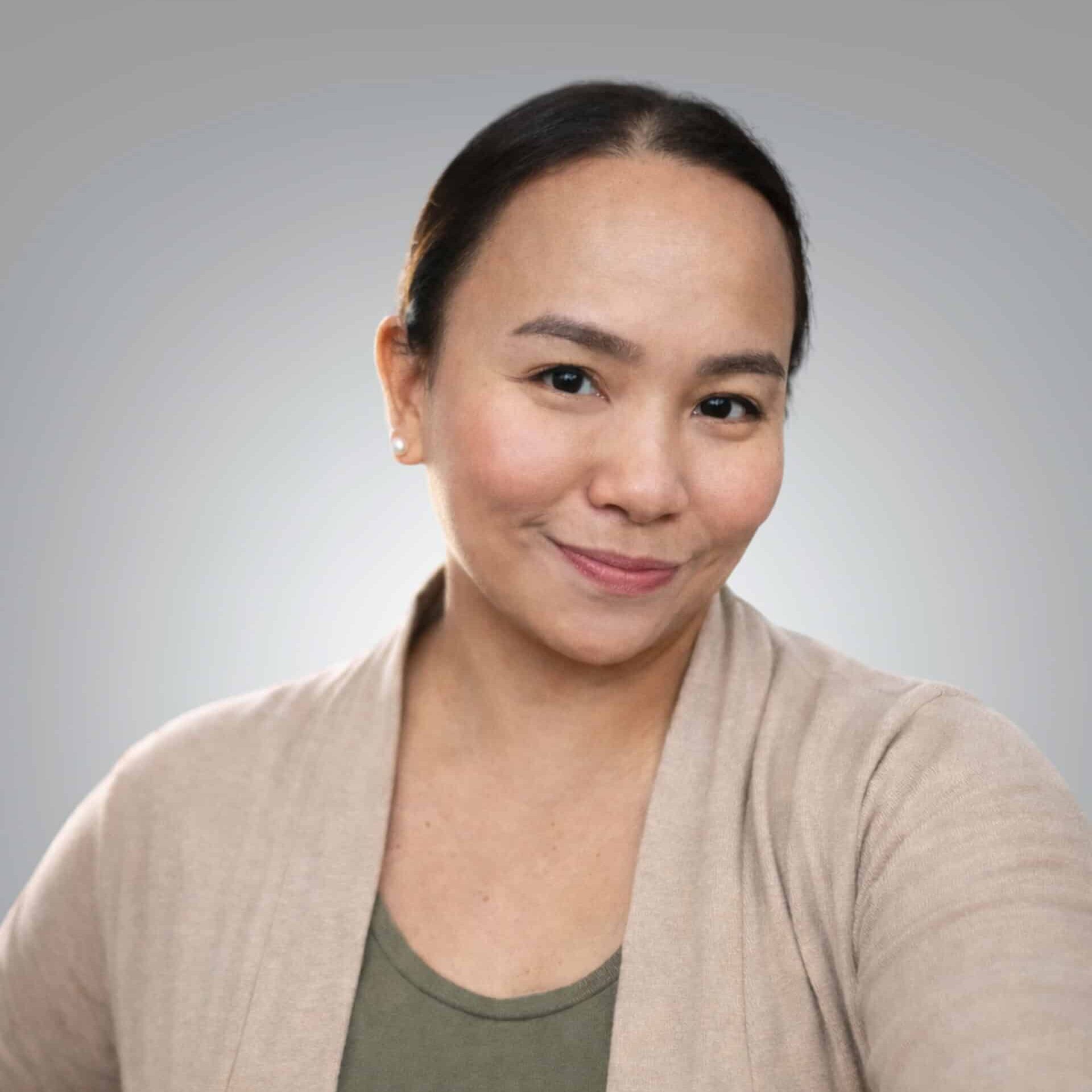 Lee-Anne Cunanan RMT MOT professional headshot with soft grey background and natural studio lig - Red Leaf Wellness Edmonton