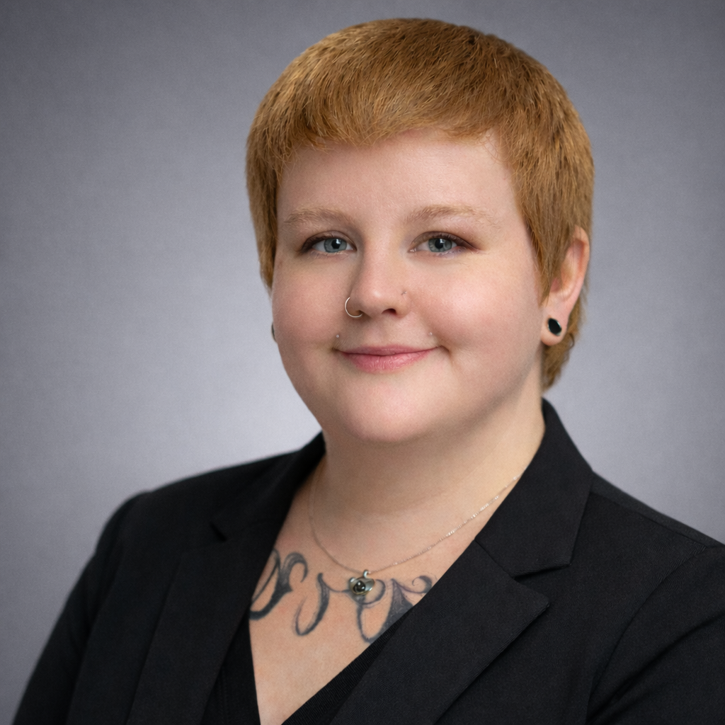 Professional headshot of Kristie Harrison, RMT and MOT, wearing a black blazer against a neutral gray studio background.
