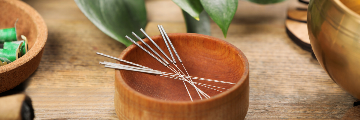 Acupuncture needles in a wooden bowl used in traditional acupuncture at Red Leaf Wellness Edmonton