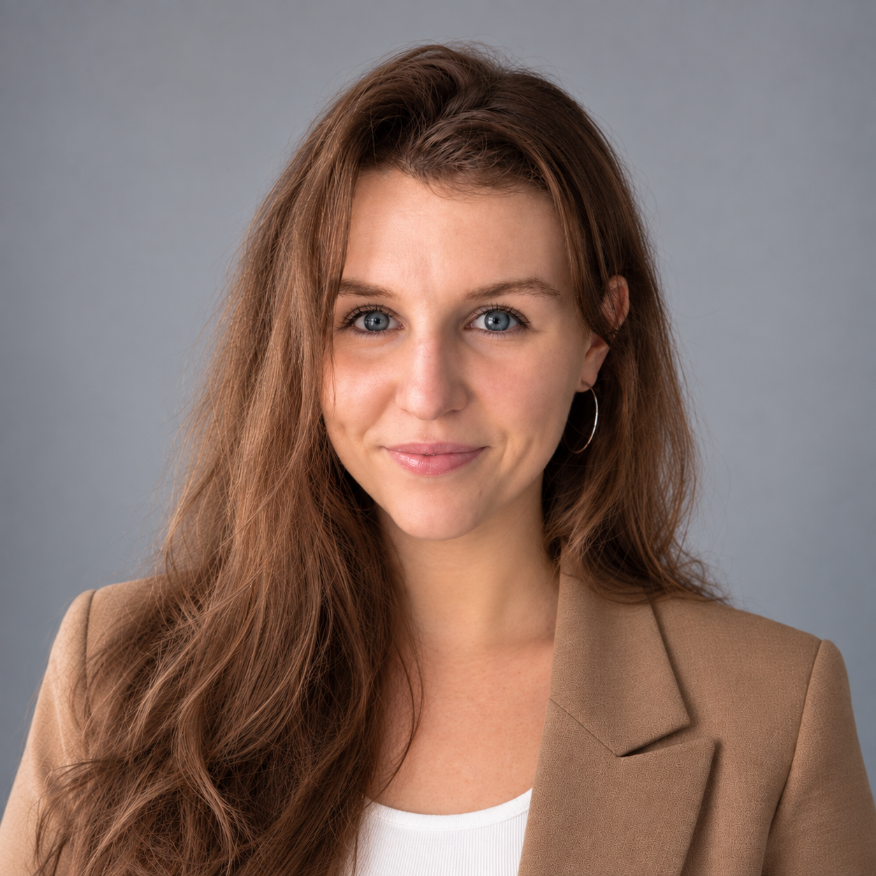 Professional headshot of Dr. Riley Forbes, ND, a naturopathic doctor focused on women’s health at Red Leaf Wellness, wearing a camel blazer against a soft gray background.